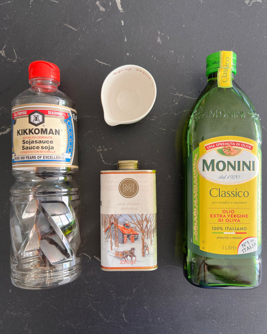 Bottles of soja sauce, maple syrup, olive oil and a measuring cup
