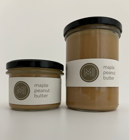 a medium size and a tall size maple peanut butter jars side by side with black lids on a white background