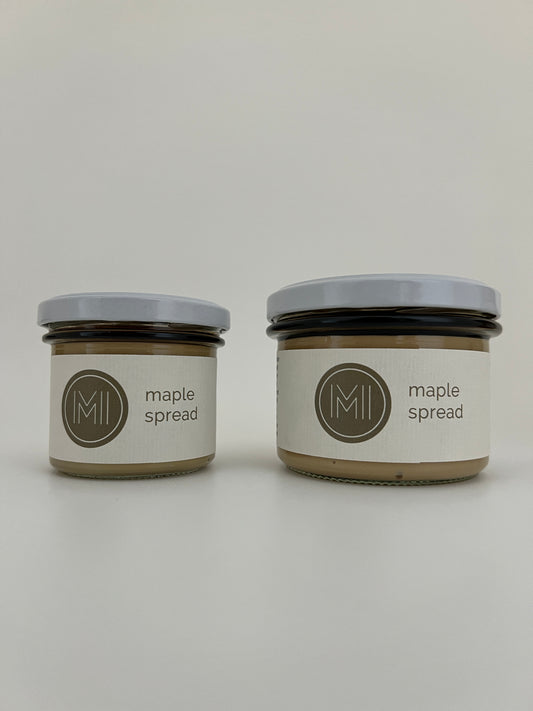 a small size and a medium size maple spread jars with white lids side by side on a white background