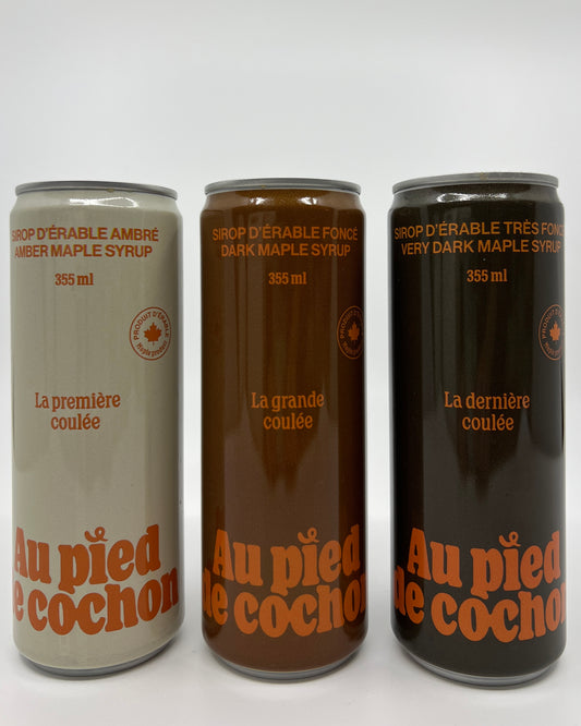 3 side by side tin bottles of maple syrup, on the left, an amber maple syrup in a beige bottle, in the middle a dark maple syrup in a brown bottle and on the rights a very dark maple syrup in a darker brown bottle