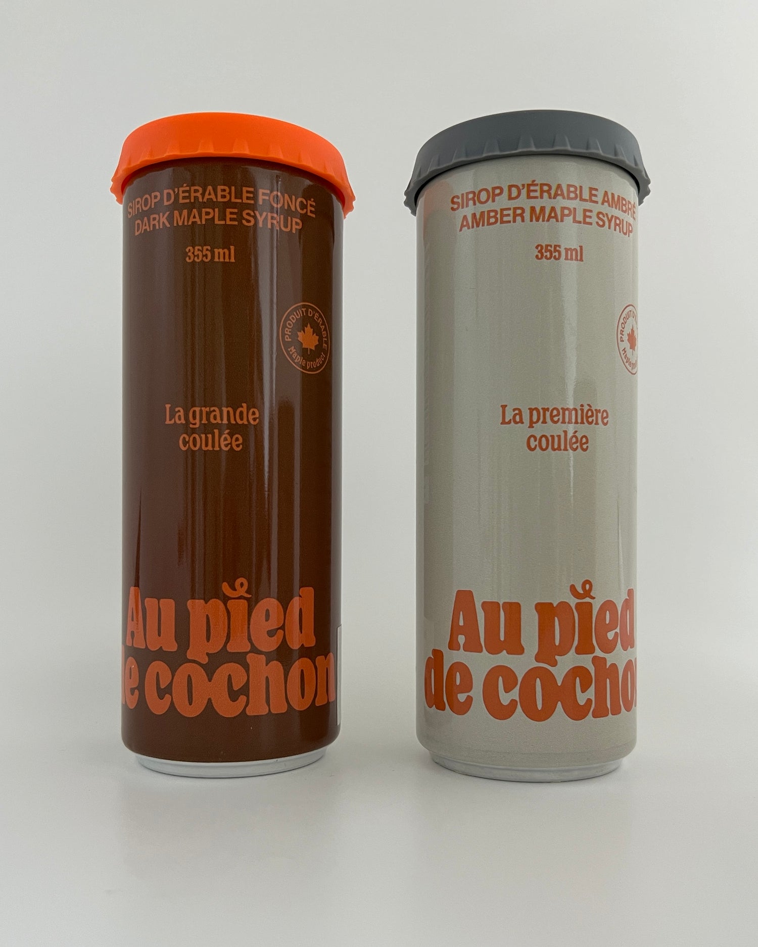 2 bottles of maple syrup 355ml, one dark named la grande coulée, one of amber maple syrup called la première coulée, both with silicon lid on a white background