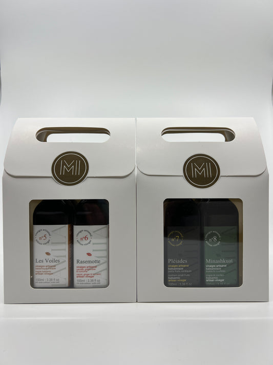 2 discovery sets with each 2 bottles of maple vinegars presented in 2 side by side white paper bag with window showing the products all aligned