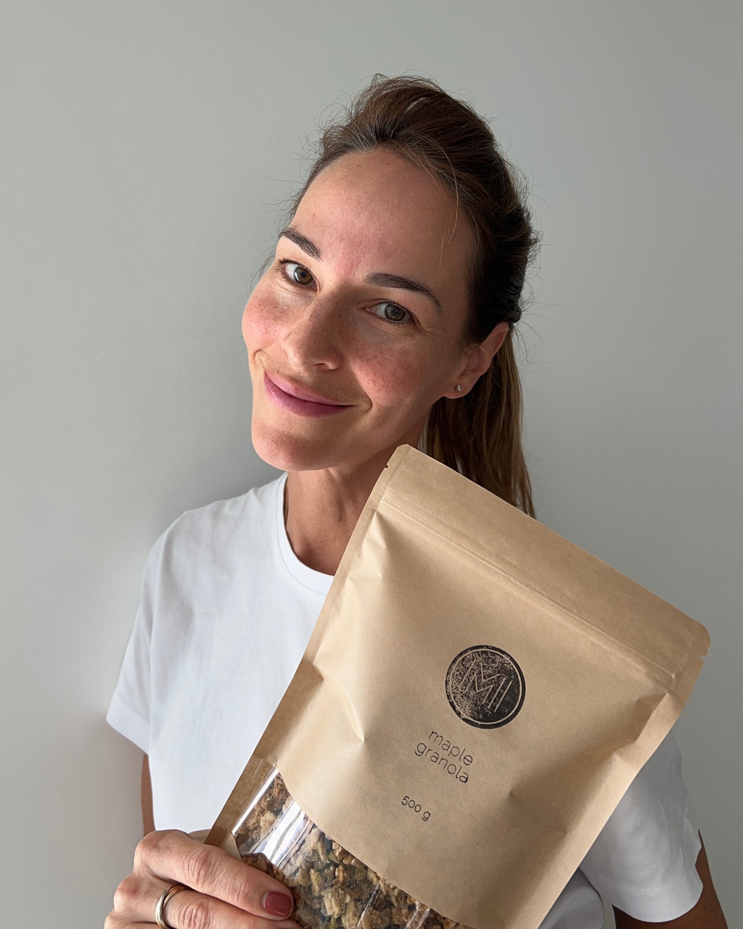 A picture of Marie-Eve smiling and holding a see-through granola bag