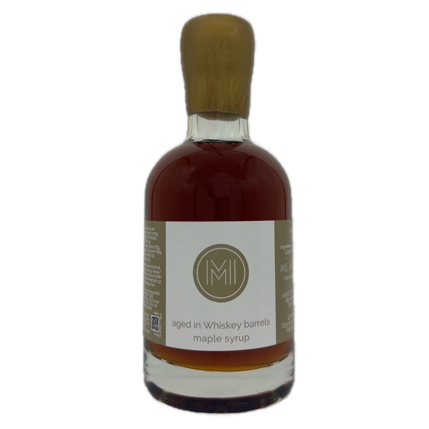 A bottle of aged in Whiskey barrels maple syrup with a light wood cap and a white label featuring a gold, set against a plain white background.