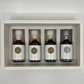 Four bottles of maple syrup, 3 with white wax plus one with grey wax, in a decorative box with a plain background