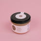A jar of maple peanut butter taken from the top on a pink background