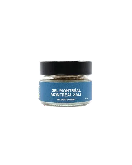 A small glass jar of Sel Montréal Montreal Salt from Sel St-Laurent  with a black lid and a blue label, centered on a plain white background.