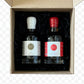 Two bottles of maple syrup in a cardboard box on a wooden surface