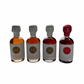4x50ml side by side bottles of golden, amber, dark and spicy maple syrup  standing with no background