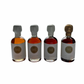 4x50ml side by side bottles of golden, amber, dark and whiskey maple syrup  standing with no background