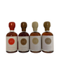 4x50ml side by side bottles of spicy, coffee, vanilla and whiskey maple syrup standing with no background