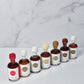Set of small bottles of maple syrup with labels on a marble surface