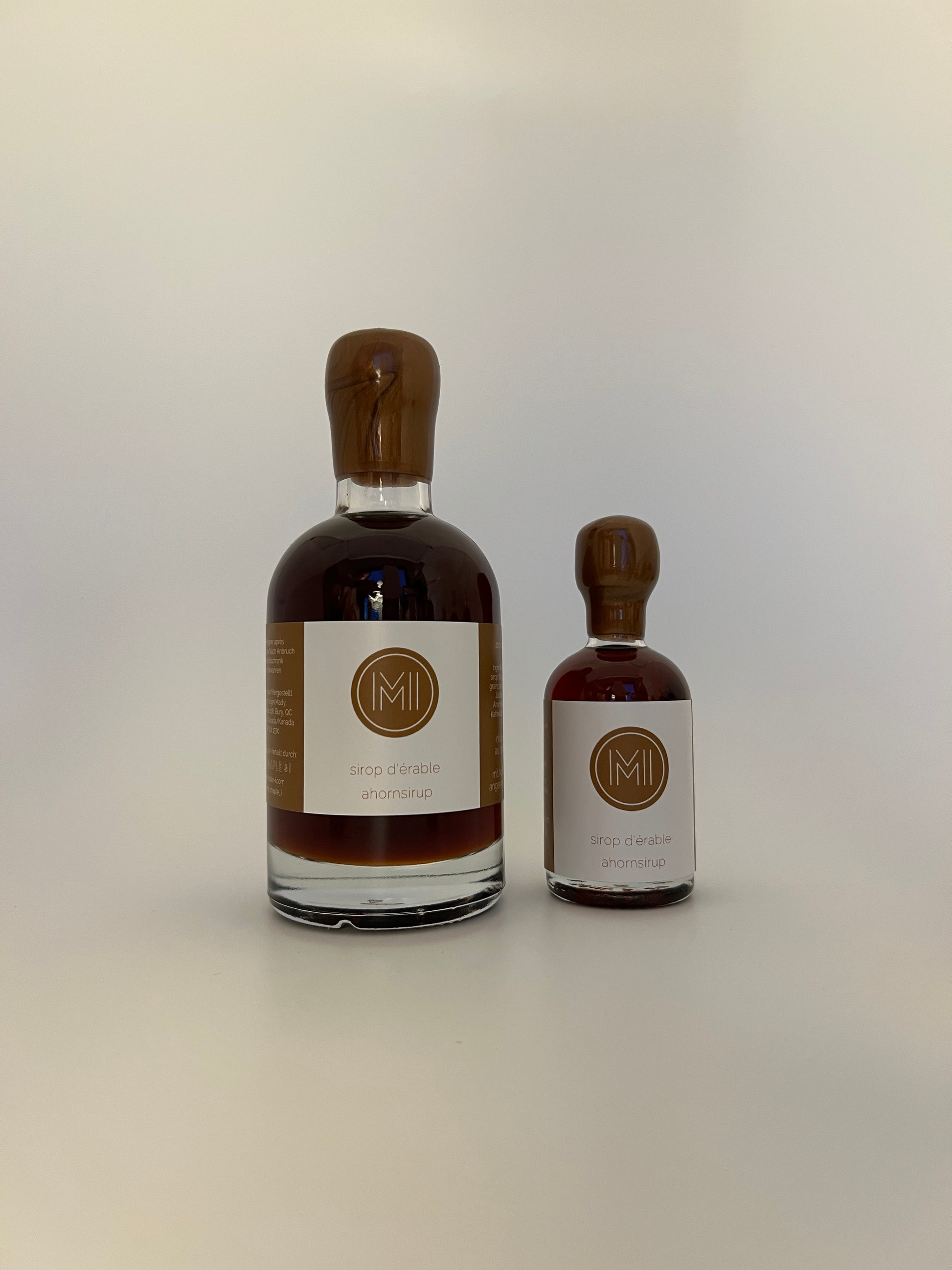 2 side by side bottles of coffee infused maple syrup, one bigger one on the left and a smaller one on the right 