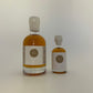 2 side by side bottles of golden maple syrup, one bigger one on the left and a smaller one on the right 