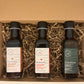 3 side by side bottles of maple vinegars presented in a brown box with straw 