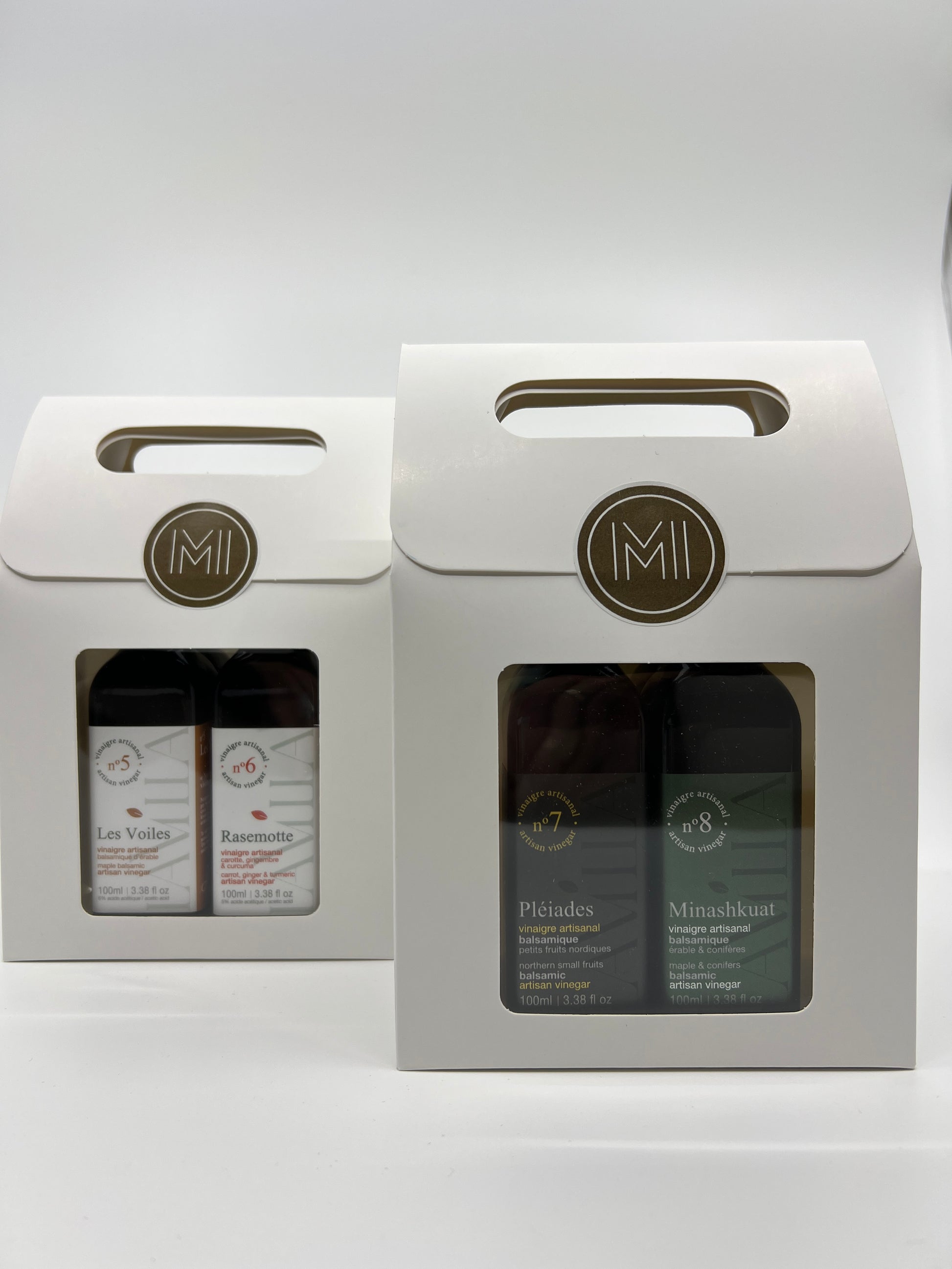 2 discovery sets with each 2 bottles of maple vinegars presented in 2 side by side white paper bag with window showing the products no.7 and no.8 in first row 