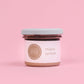 A jar of maple spread on a pink background