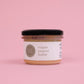 A jar of maple peanut butter on a pink background
