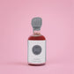 Bottle of smoked maple syrup on a pink background