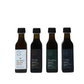 Four small dark glass bottles of olive oil arranged in a row on a plain white background. The labels read Les Voies, Pélades, Mirashasat, and Corbeau.