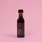 Bottle of Pleiades olive oil on a pink background