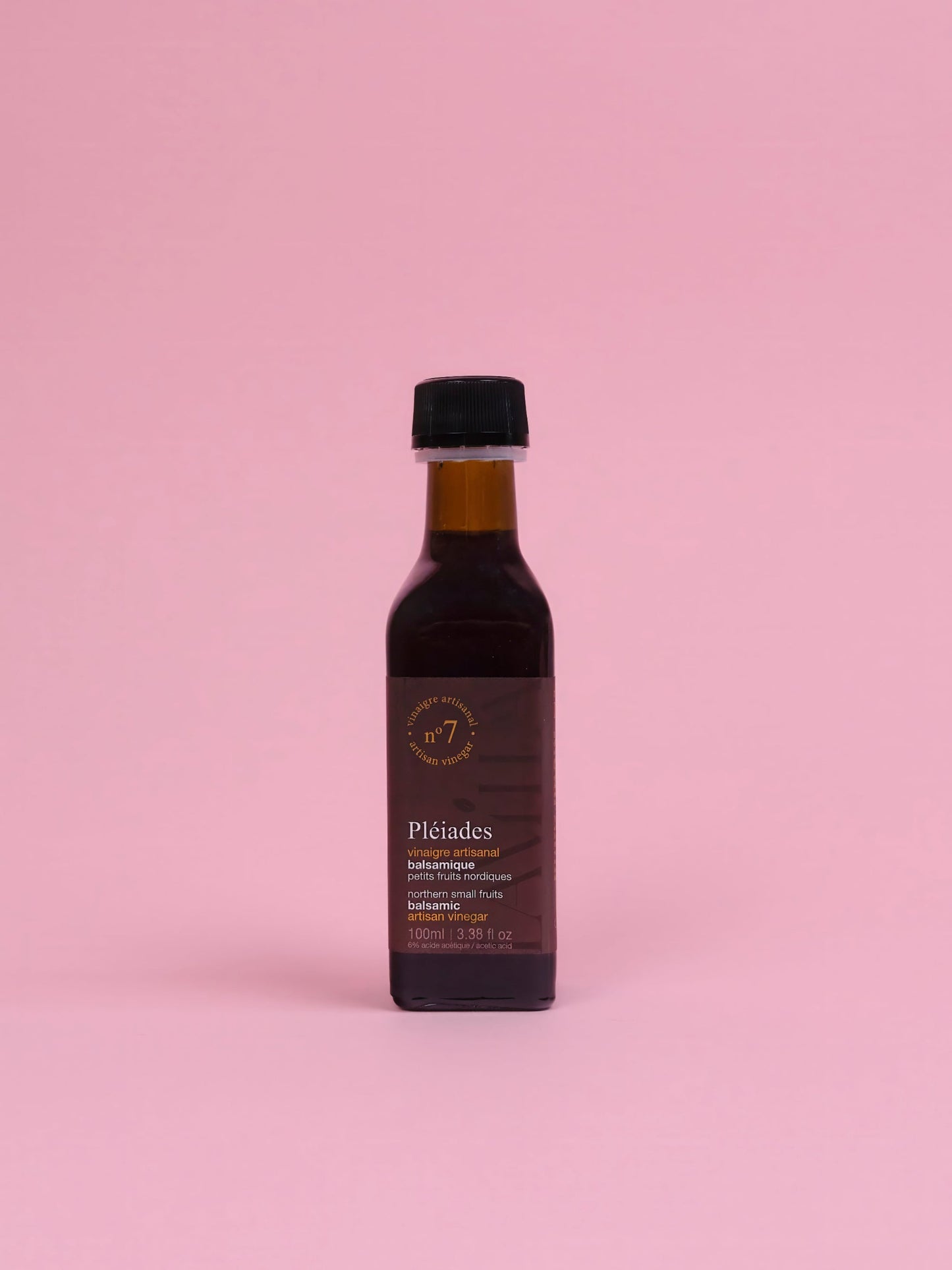 Bottle of Pleiades olive oil on a pink background